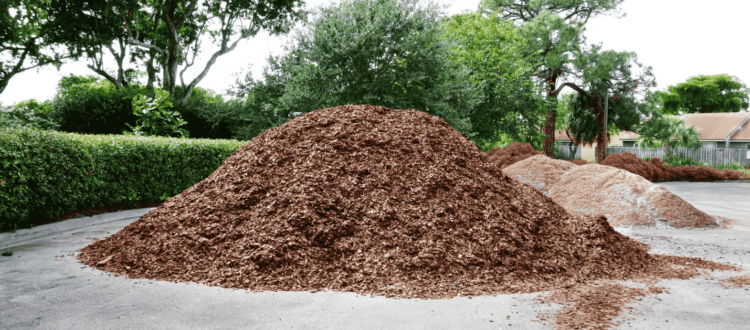 A pile of bark mulch in a drive way.